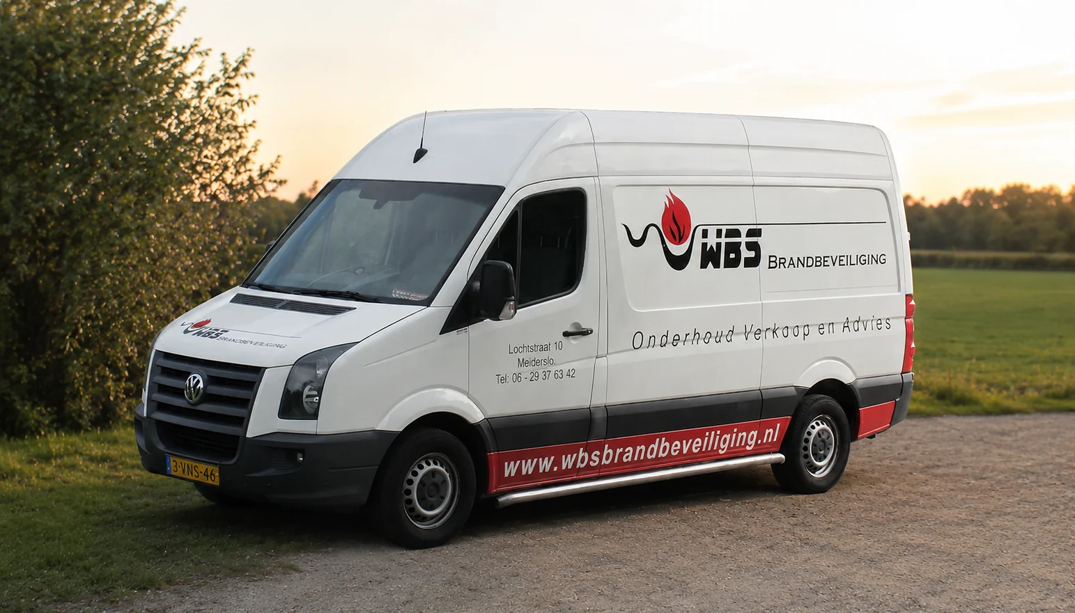 Een bedrijfsbus van WBS Brandbeveiliging bij avondlicht, met het opschrift Onderhoud, verkoop en advies